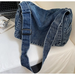 Dettaglio borsa a tracolla in denim blu scuro con tracolla regolabile e fibbia nera