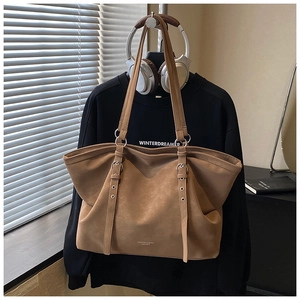 Detail of khaki leather tote bag with metal ring hardware and fashion branding
