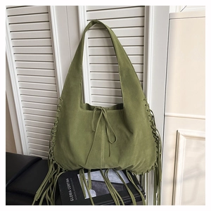 Detail of olive green suede hobo bag featuring bohemian side lacing and long tassels