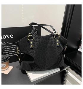 Close-up of black leopard print texture on a large tote bag with gold ring hardware