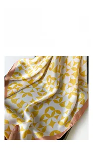 Detailed fabric texture of the satin silk scarf featuring yellow geometric floral patterns