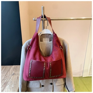 Detail der roten Wildleder Hobo-Tasche mit silbernen Nieten und großen Taschen