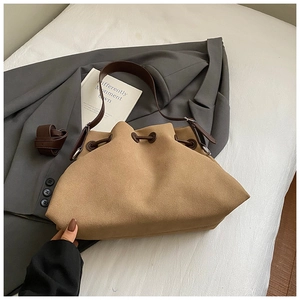 Close-up of brown suede drawstring bucket bag featuring a soft matte texture and leather straps
