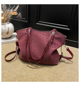 Detail of burgundy leopard print tote bag with premium gold hardware and dual straps