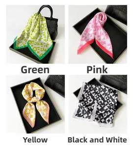 Detail view of geometric floral silk scarves in green, pink, yellow, and black and white