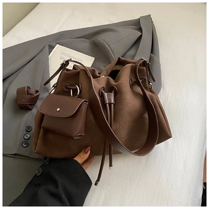 Macro detail of coffee brown suede bucket bag with drawstring and mini pouch attachment