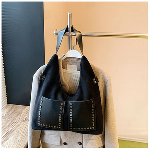 Detail der schwarzen Wildleder-Hobo-Tasche mit glänzenden Taschen und Metallnieten