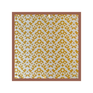 Flat lay of a yellow and white geometric silk scarf with a brown border detail