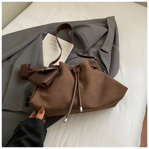 Macro detail of brown frosted leather bucket bag with drawstring and small pouch