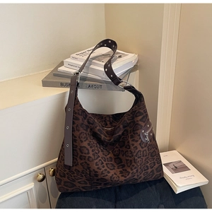 Close-up of leopard print hobo bag with wide grommet strap and metallic hardware