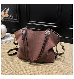 Detail view of brown faux suede tote bag with leather straps and gold metal ring connectors