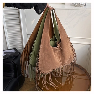 Close-up of bohemian suede tote bag featuring long decorative fringes and tie closure