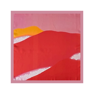Detailed close-up of a square silk scarf featuring abstract red and pink mountain patterns