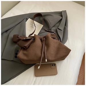 Detail of dark brown faux suede bucket bag with drawstring closure and matching mini pouch
