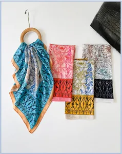 Detailed view of four colorful satin square scarves with floral and bird prints