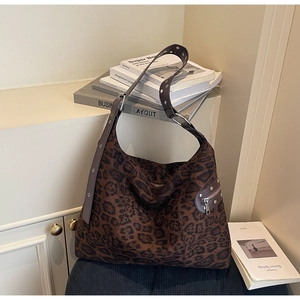 Detail of the leopard print hobo bag showing the suede texture and metal grommet strap