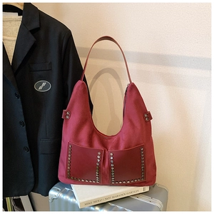 Detailansicht der weinroten Hobo-Tasche mit Nieten und weicher, matter Oberflächentextur