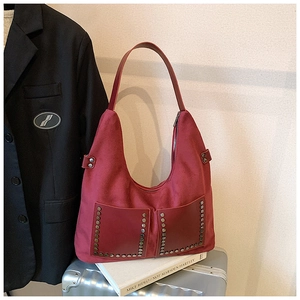 Detailansicht der roten Wildleder-Tasche mit Metallnieten auf Vintage-Koffern