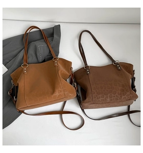 Detail of large PU tote bags in solid tan and leopard print with adjustable straps