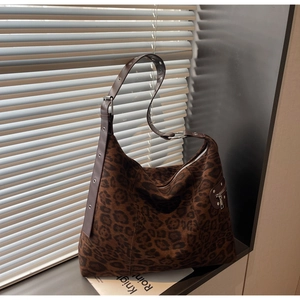 Detail of leopard print suede shoulder bag with metallic eyelets and side zipper