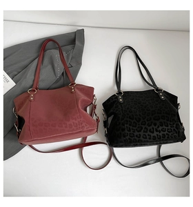 Detail view of large leopard print tote bags in red and black with detachable straps