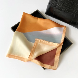 Detailed view of square silk scarf with oil painting pattern folded on a black display tray