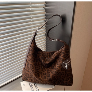 Detail showing plush leopard print texture with metallic rings and silver stud accents