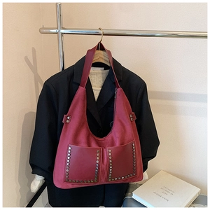 Detailansicht der weinroten Vintage-Tasche aus Wildleder mit Nieten und Fronttaschen