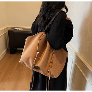 Sac fourre-tout en daim marron avec détails à franges porté à l'épaule à l'intérieur
