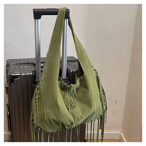 Macro shot of olive green suede hobo bag detailing long fringe and leather drawstring ties