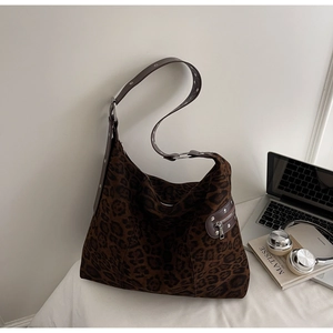 Macro shot of faux suede leopard print hobo bag with vintage metal zipper and eyelet detail