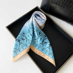 Detailed view of square satin scarf with light blue vintage floral and bird illustration