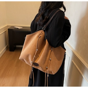 Vue mannequin d'un grand sac cabas en daim camel avec de longues franges à cordon