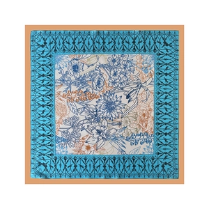 Detailed flat lay of a satin scarf showing intricate floral prints and blue borders