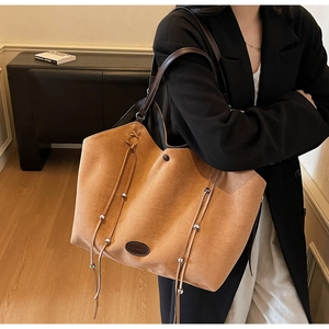 Détail du grand sac cabas en daim marron avec cordon de serrage et poignée en cuir