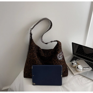 Macro detail of leopard print tote bag with metal eyelet strap and tablet for size display