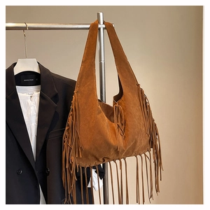 Detailed view of the brown suede tote bag featuring long fringes and bohemian vintage style