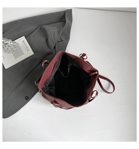 Detail of dark red tote bag interior featuring black lining and zipper pocket