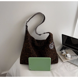 Macro view of leopard print tote bag with metal eyelet strap and side zipper detail