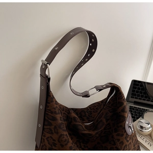 Detail view of leopard print faux suede tote bag with metal eyelet strap and silver zipper