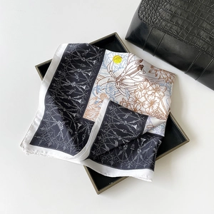 Detail of premium satin square scarf featuring elegant floral patterns and a smooth finish