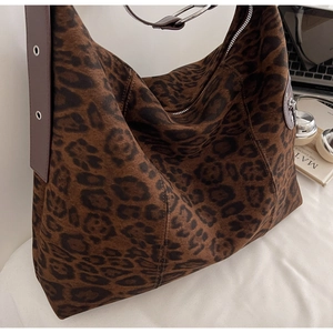 Detail view of large leopard print tote bag with brown straps and silver metal eyelets