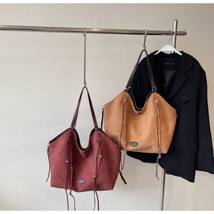 Détails de grands sacs cabas bordeaux et havane avec franges et clous argentés