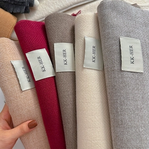 Detailed close-up of herringbone texture and multiple solid colors of these winter scarves