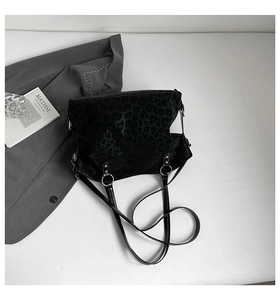 Detail of black leopard print embossed tote bag with slim shoulder straps and metal rings
