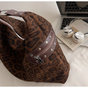 Macro detail of leopard print canvas bag with silver rivets and metal ring hardware