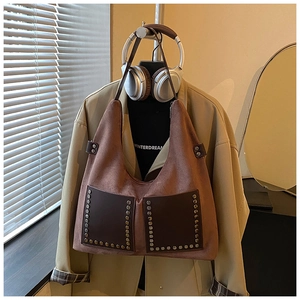 Detailaufnahme der braunen Wildleder-Tragetasche mit Metallnieten und Taschenelementen