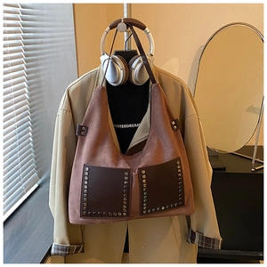 Makrodetail der Retro-Nietentaschen an einer Vintage-Wildleder-Hobo-Bag für Damen