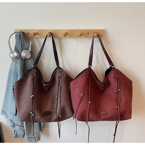 Détails de cabas en daim rétro avec franges en cuir et accents de perles métalliques