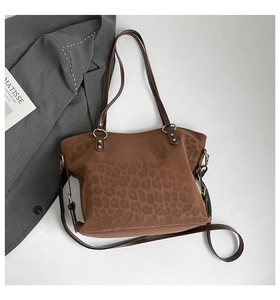 Detail view of brown leopard print tote bag with metallic hardware and shoulder strap